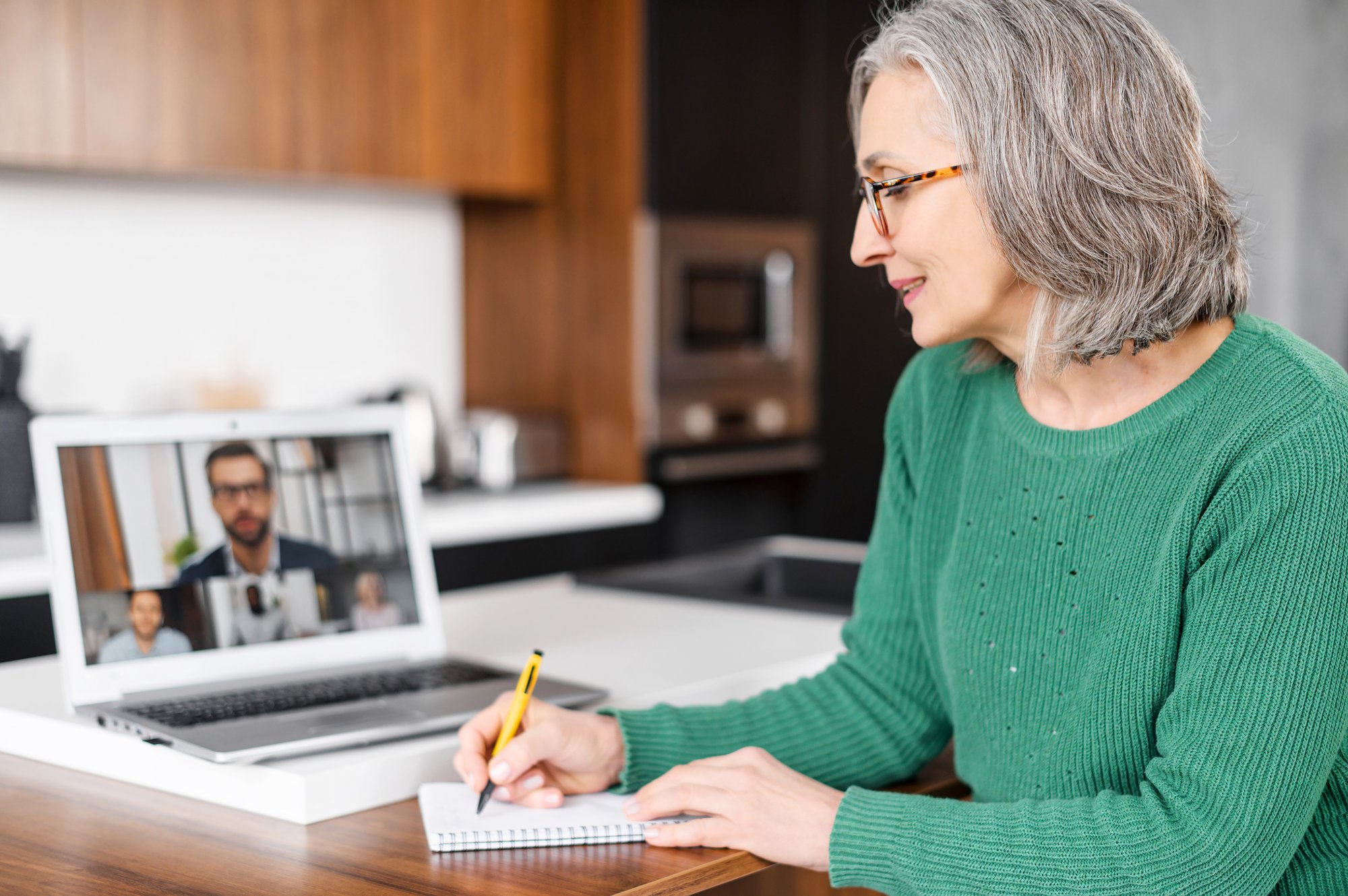 Mature woman talking to colleagues on Zoom